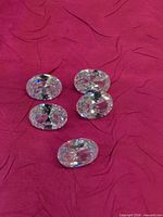 Five oval faceted clear stones on fabric backdrop
