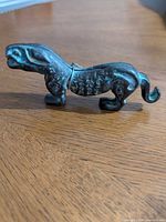 Left side view of bronze cat showing patina, form, and metal band