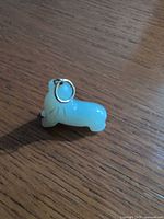 Front left view of opalescent glass seal pendant showing jump ring and color