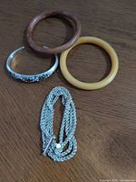 Group shot of two Bakelite bangles, rhinestone cuff bracelet and multi-strand necklace