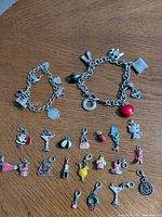 Overall view showing two charm bracelets and group of loose charms