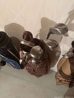 Top view of brown leather bag showing assorted club heads marked Method and Campbell