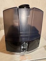 Front view of black and gray Air-O-Swiss cool mist humidifier showing dual translucent tanks and control dial