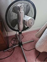Full view of Airworks pedestal fan showing stand, grille and power cord