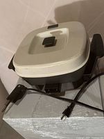 Electric skillet assembled with lid and power cord visible