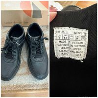 Pair of black leather shoes and size/material tag