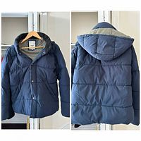 Front view of navy puffer jacket on hanger