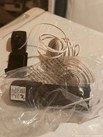 Two black wired garage door safety sensors with bundled cables and brackets, in plastic