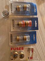 Four blister packs of plug fuses and one loose fuse displayed on table