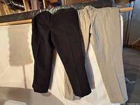 Black and khaki pants hanging side by side