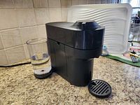Front view of Nespresso Vertuo machine showing water reservoir and drip tray