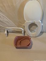 All three items together: raised toilet seat with lid, safety rail, pink bedpan