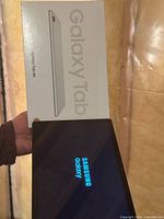 Tablet screen displaying Samsung logo with box shown