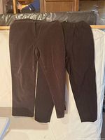 Both pants hanging side by side showing colors and styles