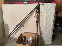 Two pairs red Huber skis with bindings, poles bundled, boots in box