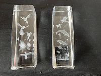 Both crystal paperweights side by side showing etched designs