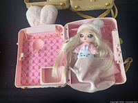 Pink bunny backpack case open showing blonde doll and interior