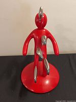 Front view of red human-shaped knife block without knives