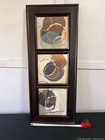 Front view of framed abstract artwork showing three panels and frame finish