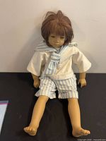 Front view of doll seated showing outfit and overall condition