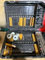Open DeWalt case showing assorted bits, hole saws and socket pieces