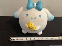 Front view of Cinnamoroll resin piggy bank with tape for scale