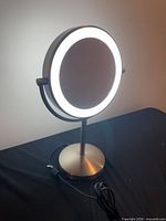 Front view showing LED ring illuminated and brushed nickel base