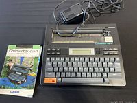 Casio CW-11 typewriter with AC adapter and manuals overview