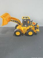 Left side view of CAT wheel loader showing bucket raised