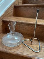 Glass decanter and disassembled stainless steel stand on wooden steps