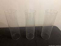 Front view of three clear glass chimneys standing upright