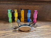 Front view of five mini flashlights and crab-shaped multi-tool