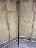 Full view of black curtain rod leaning against wall