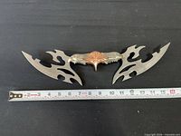 Full view of double-bladed fantasy knife with measuring tape showing length