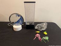 Full lot overview showing round sand art lamp, bubble column lamp, aquatic toys and bag of cords