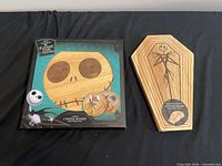 Retail-boxed Circo round cheese board next to coffin-shaped cutting board
