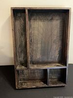 Front view of wooden wall shelf showing four compartments