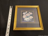 Front view showing print, mat, and gold frame with measuring tape for scale