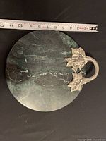 Top view of marble board showing color, veining, handle and tape for scale
