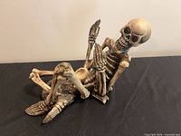Skeleton wine bottle holder side view reclining pose