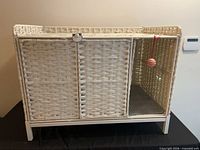 Front view showing enclosure, double doors, hanging toy