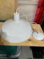 Side view of white pendant lamp showing shade, canopy and cord