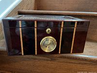 Front view of lacquered wood humidor showing hygrometer and lock