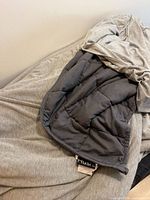 Weighted blanket spread out showing outer gray jersey cover and inner quilted layer