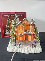 Front view of illuminated village house with box in background