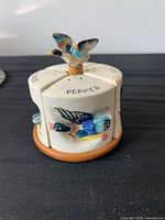 Pepper shaker side showing duck motif and bird finial