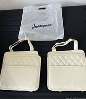 Front view of both beige quilted car caddies with packaging bag