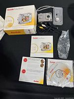 Full set showing box, camera, cables, dock insert, strap, manuals, CD