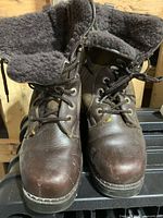 Front view of both boots showing leather uppers, laces, shearling cuffs