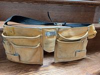 Front view showing dual pouches, pockets, hammer loop, belt clip
